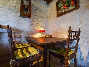 a table in a room with two chairs and a lamp at Charming typical Auvergne cottage in Teilhet