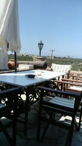 mesa y sillas en la parte superior de un patio en Charouda Stone Tower, en Pyrgos Dirou
