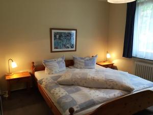 ユイストにあるFerienwohnungen Haus Miraのベッドルーム1室(大型ベッド1台、テーブル上のランプ2つ付)