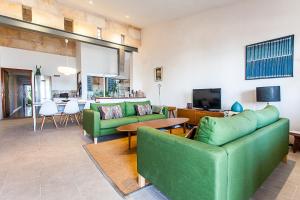 a living room with two green couches and a television at Marina in Colonia Sant Jordi