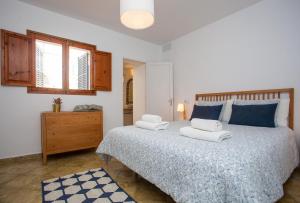 Un dormitorio con una cama grande con toallas. en Marina, en Colonia de Sant Jordi