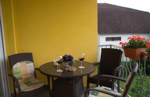 a table and chairs with wine glasses on a balcony at Bodó Park Apartment in Hévíz