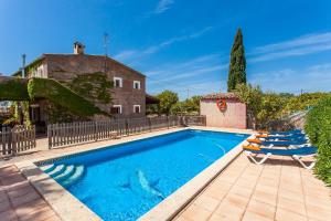 a swimming pool with two lounge chairs and a house at Sa Volta Nova in Porreres