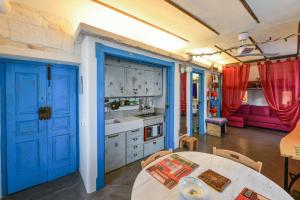 uma cozinha com portas azuis e uma mesa em Apartment Attico panoramico di Martina Franca em Martina Franca