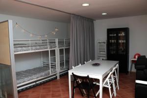 a room with a table and two bunk beds at Casa Paz do Outeiro in Paredes de Coura