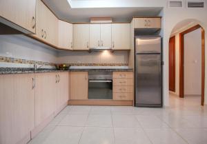 a kitchen with wooden cabinets and a stainless steel refrigerator at Cosy Cwtch 2 in Los Alcázares