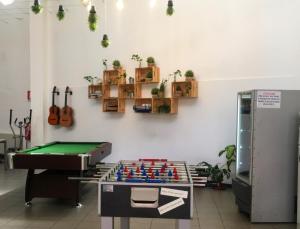 a ping pong table in a room with a pool at Mio Hostel in Milan