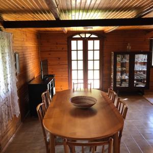 uma sala de jantar com uma mesa de madeira e cadeiras em Chalé Dei Fiori, 3QTS, Ambiente Ideal para a família em Venda Nova do Imigrante