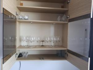 a row of wine glasses sitting on a shelf at Apartament Ana Navodari Mamaia Nord in Mamaia Nord +11 photos