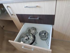 a kitchen with two frying pans in a drawer at Apartament Ana Navodari Mamaia Nord in Mamaia Nord