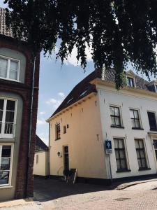 a white building with a black roof at B&B Het Rode Hert in Doesburg