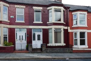 a red brick house with white doors on a street at Sweet Dreams Residence, close to Penny Lane in Liverpool