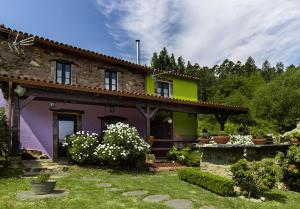 una casa en un jardín con flores en el patio en Paraíso Ortegal, en Feás