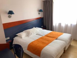 Habitación de hotel con cama con manta naranja en Yatt Hotel, en Arcachon