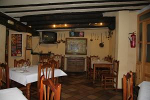 a dining room with tables and chairs and a television at Posada Tintes in Cuenca