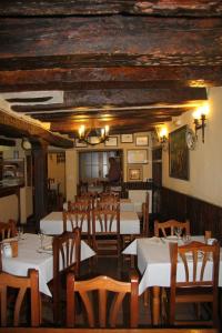 a dining room with white tables and wooden chairs at Posada Tintes in Cuenca