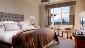 ein Schlafzimmer mit großem Bett und großem Fenster in der Unterkunft Parknasilla Resort & Spa in Sneem