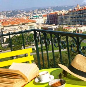 a yellow table with a hat and a book on a balcony at Chez Kari-top location in charming old town in Nice