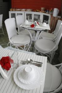 una mesa blanca con platos blancos y cubiertos en Pousada do Bita, en Fernando de Noronha