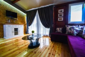 sala de estar con sofá púrpura y mesa en Urke - Ada Bojana en Ulcinj