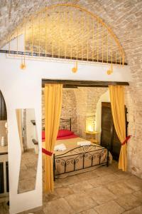 a bedroom with a large bed in a stone wall at La Casa di Vale in Martina Franca