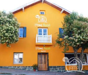 an orange house with a porch and a balcony at HOPA-Home Patagonia Hostel in San Carlos de Bariloche