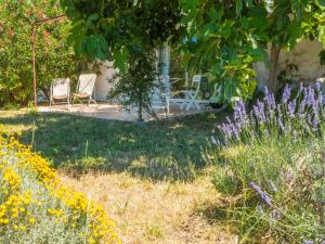 a garden with two chairs and purple flowers at Beautiful holiday home with pool in Autignac