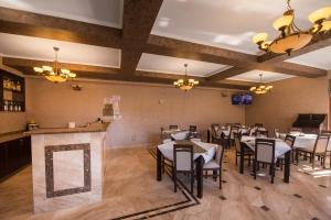 a dining room with tables and chairs and a bar at Casa Soarelui in 2 Mai