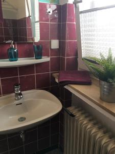 a bathroom with a white sink and a radiator at Apartement "Sam" in Wilhelmshaven