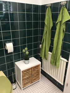 baño con paredes de azulejos negros y toallas verdes en Apartement "Sam", en Wilhelmshaven