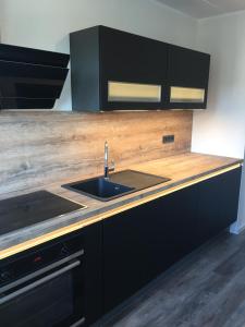 a kitchen with a sink and a wooden counter top at Apartement "Sam" in Wilhelmshaven