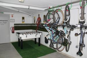 um quarto com bicicletas penduradas na parede e uma mesa em Hostel Supremo em Armação de Pêra