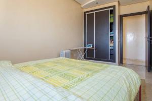 Un dormitorio con una cama con una manta amarilla. en Res Mario 3 Lovely Apartment With Balcony & Sea View Free Wifi en Casablanca