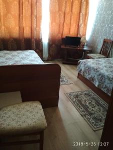 a bedroom with two beds and a chair and a table at Hotel Zvenigorod in Zvenigorod