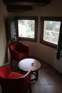 een kamer met 2 ramen en een tafel en stoelen bij Hostal San Pedro in Cuenca
