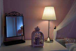 a lamp sitting on a table next to a mirror at Recanto das Vigias "Vigia do Ilheu" in Topo