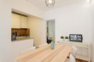 a kitchen and dining room with a wooden table and chairs at FLH Príncipe Real Bright Apartment in Lisbon