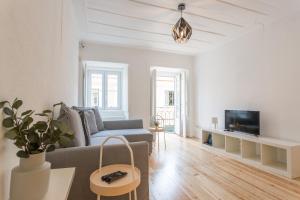 a living room with a couch and a tv at FLH Príncipe Real Bright Apartment in Lisbon