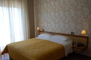 1 dormitorio con 1 cama grande y pared grande en Hotel Ristorante Donato, en Calvizzano