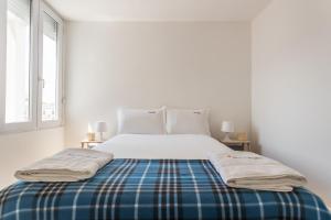 a white bedroom with a bed with a blue blanket at FLH Príncipe Real Bright Apartment in Lisbon