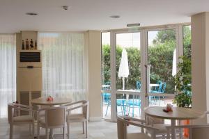 a dining room with two tables and chairs and a patio at Sunny Residence complex in Sunny Beach