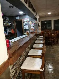 a restaurant with a row of seats at a bar at Hostal Paquito in Vejer de la Frontera