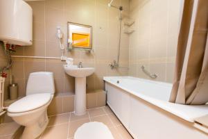 a bathroom with a toilet and a sink and a bath tub at Hotel Menshikov in Ulan-Ude