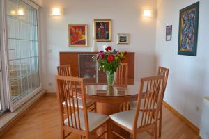 una mesa de comedor con un jarrón de flores. en Apartment Sunny en Split
