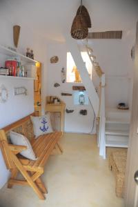 a living room with a bench and a staircase at Dandy Villas Velanidia - Fisherman's Hut - By the Sea in Panayía