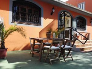 a wooden table and chairs in front of a building at Hostal Paquito in Vejer de la Frontera