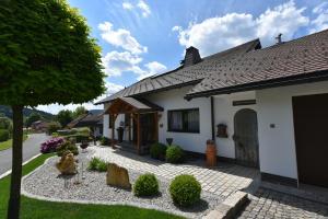 a house with a gravel driveway in front of it at Ferienwohnung Sendelbeck in Warmensteinach