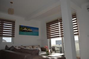 a living room with a couch and two windows at Studios Seaview in Dobra Voda
