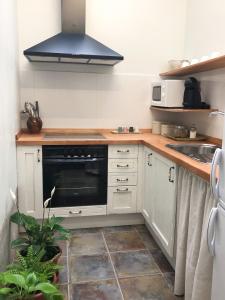 uma cozinha com armários brancos e um forno preto em Apartamento Rural La Serratilla em Alhama de Aragón