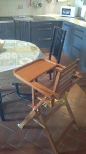 una silla de madera sentada junto a una mesa en la cocina en Casa Agostini, en Lari